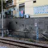 A questo punto imbocchiamo un sottopassaggio che ci permette di sbucare sulla banchina opposta, quella di via Oberdan. Di fronte a noi ora ci sono gli edifici color pastello di Madonnella, imbrattati da alcune scritte...